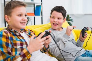 two boys that don’t yet know the impact of video games on children having a fun time while gaming